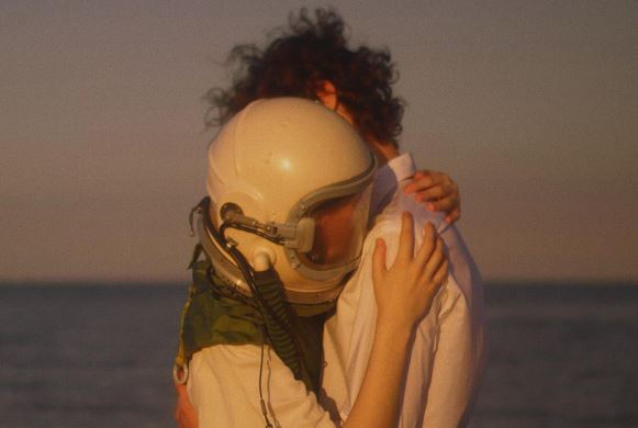 一丝萤火背烛光 《打一字》